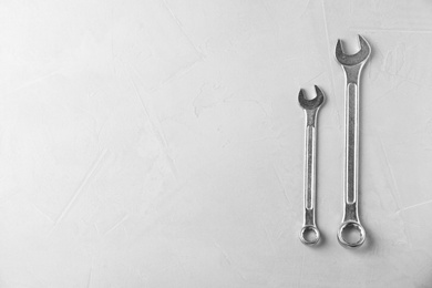 New wrenches on grey background, top view with space for text. Plumber tools