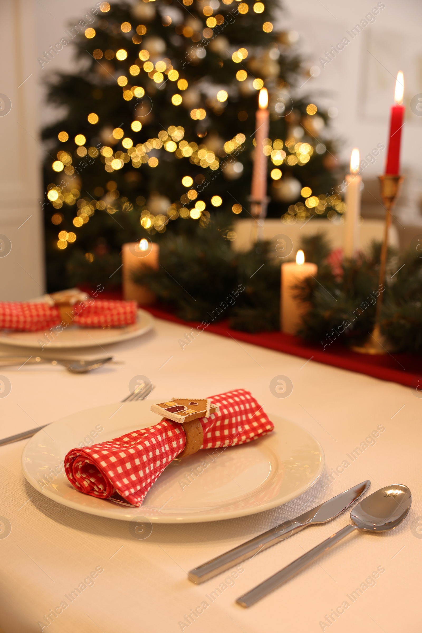 Photo of Festive table setting and beautiful Christmas decor in room. Interior design