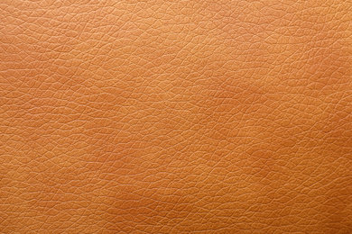 Texture of orange leather as background, closeup