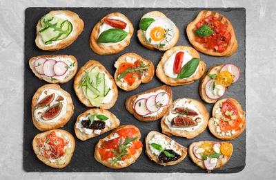 Photo of Different bruschettas on light grey marble table, top view