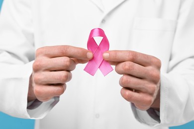Mammologist giving pink ribbon, closeup. Breast cancer awareness