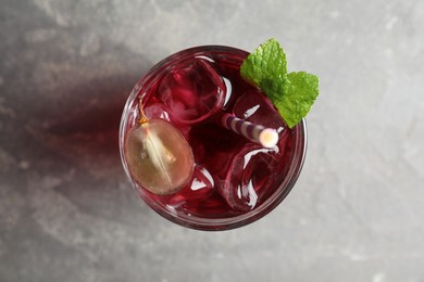 Delicious grape soda water on grey table, top view. Refreshing drink