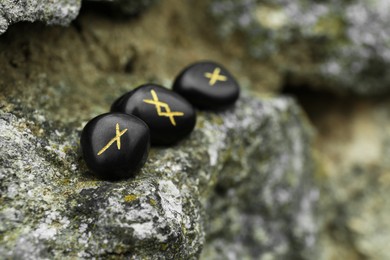 Black runes on stone outdoors, closeup. Space for text