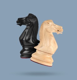 Image of Wooden chess knights in air on greyish blue background