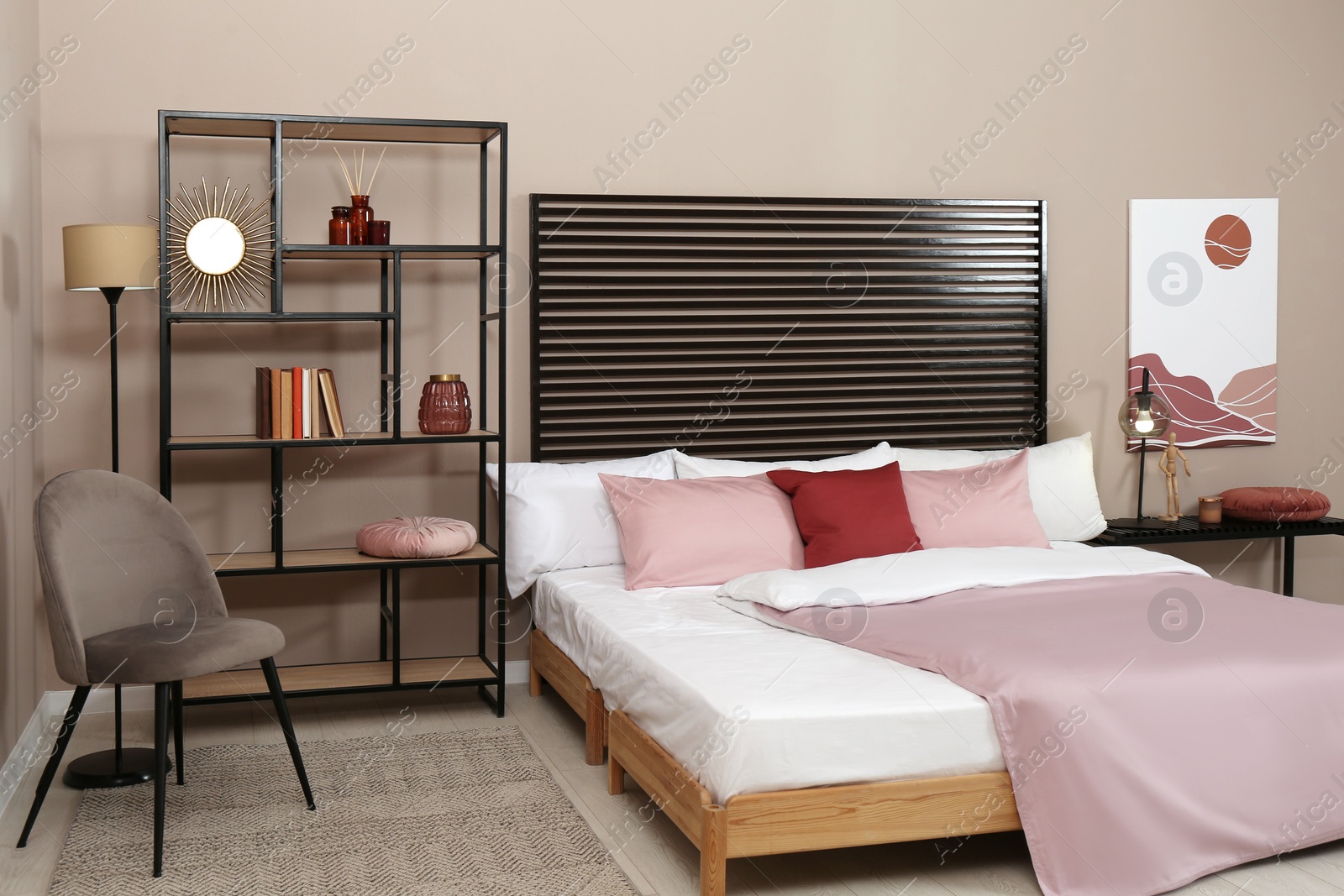 Photo of Large comfortable bed near beige wall in room. Interior design