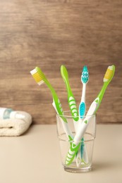 Photo of New toothbrushes on beige table. Space for text