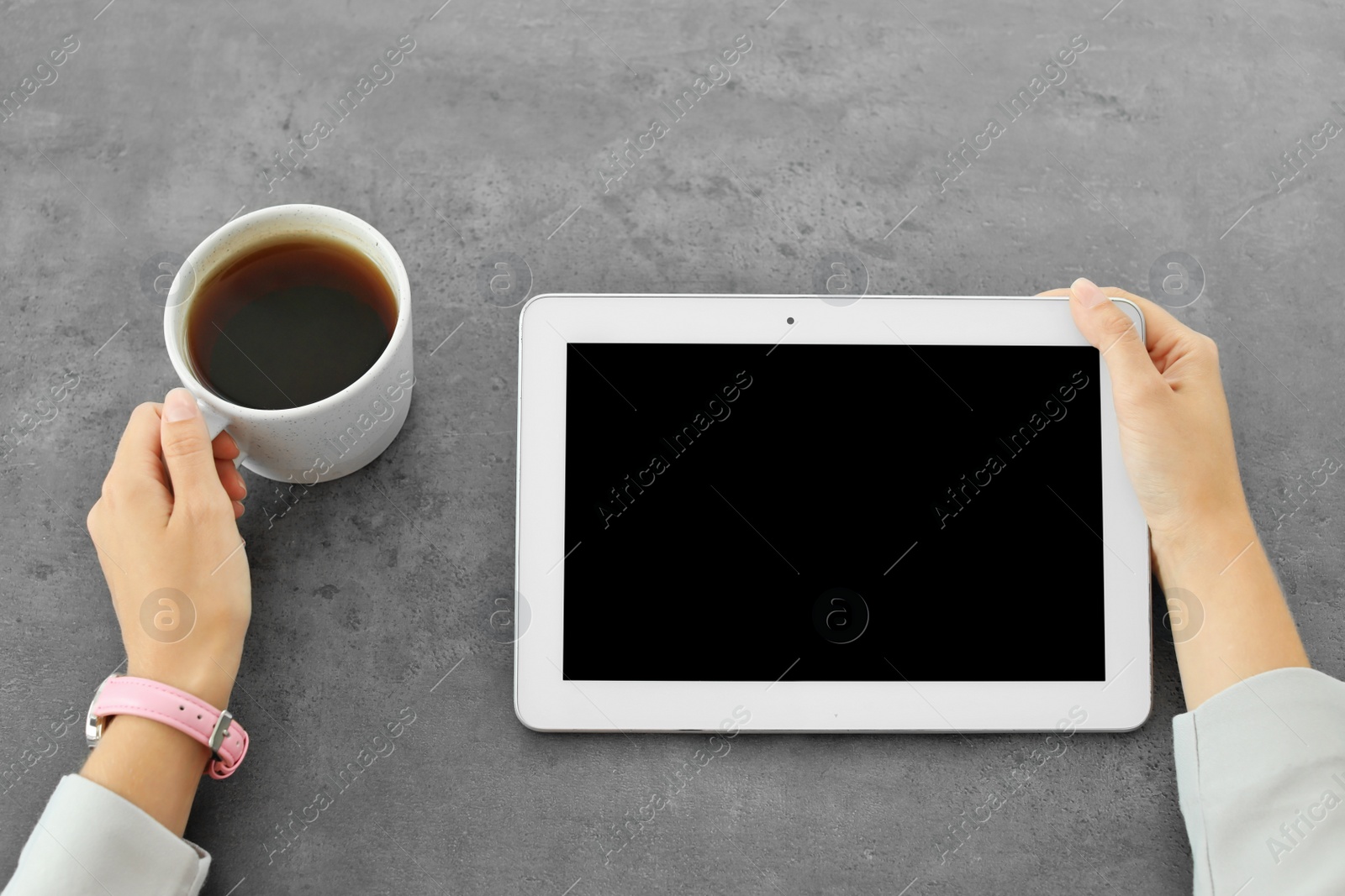 Photo of Woman holding tablet with blank screen at table. Mockup for design