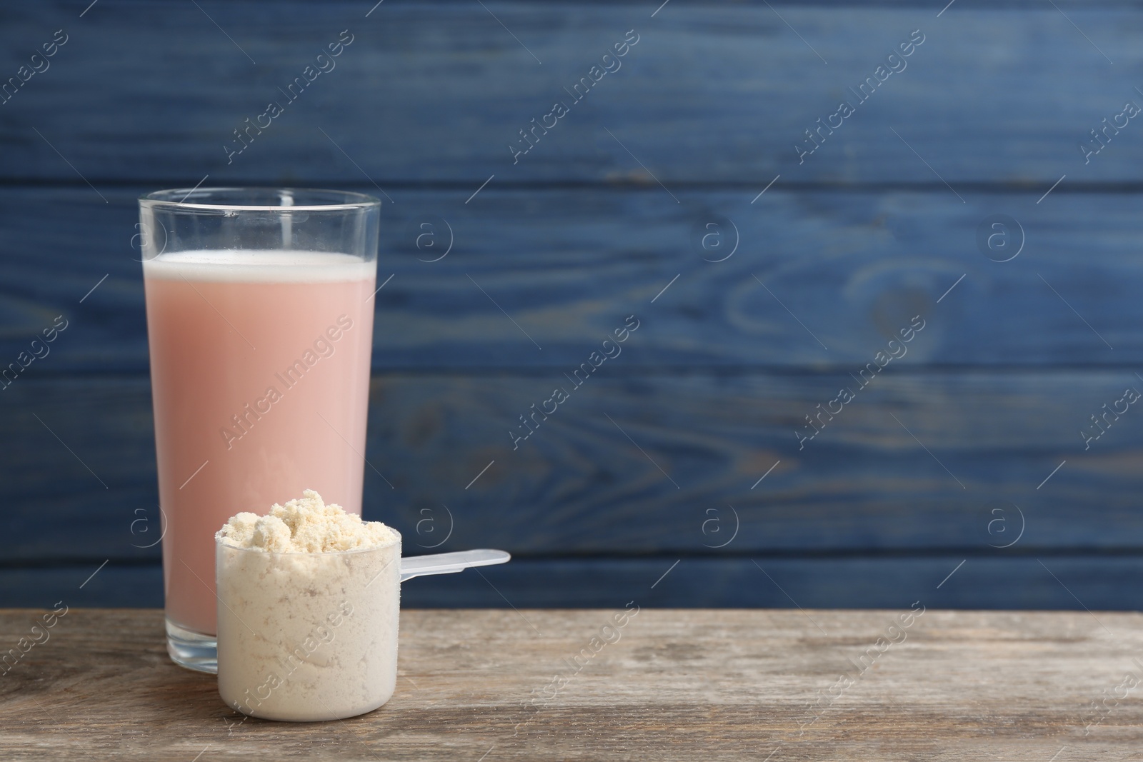 Photo of Protein shake and powder on wooden table, space for text