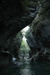 Picturesque view of clean river near cliffs and waterfall outdoors