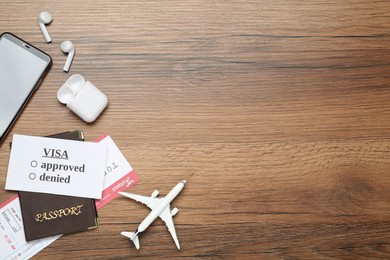 Photo of Flat lay composition with passport, toy plane and tickets on wooden table, space for text. Visa receiving