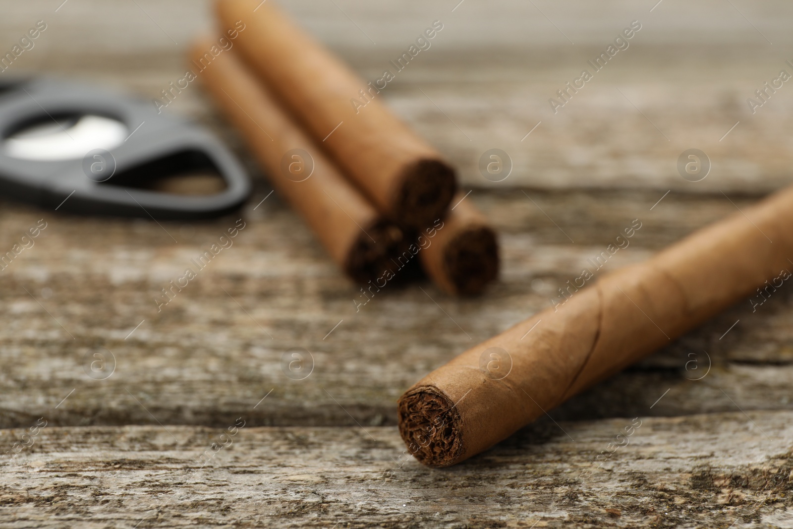 Photo of Cigar wrapped in tobacco leaf on wooden table, closeup