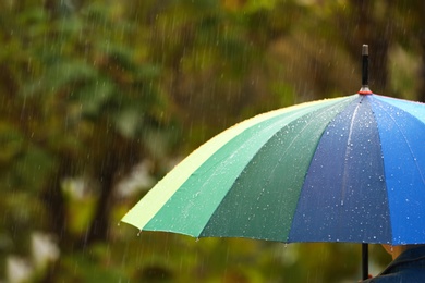 Photo of Person with bright umbrella under rain on street, closeup