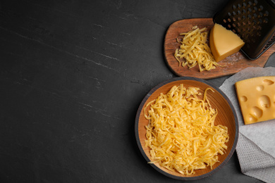 Photo of Flat lay composition with grated cheese on black table. Space for text