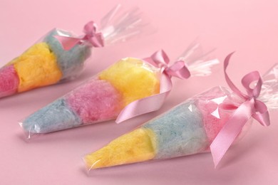 Photo of Packaged sweet cotton candies on pink background
