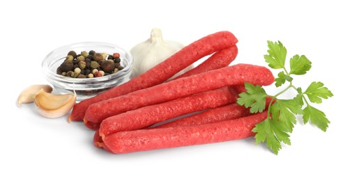 Thin dry smoked sausages and different spices isolated on white