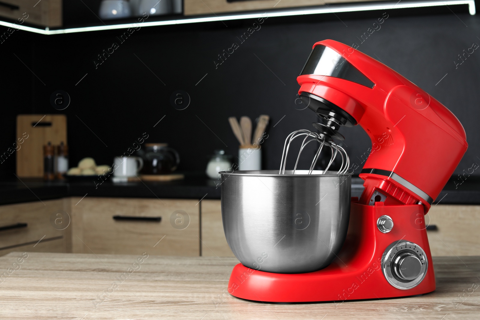 Photo of Modern stand mixer on wooden table in kitchen, space for text. Home appliance