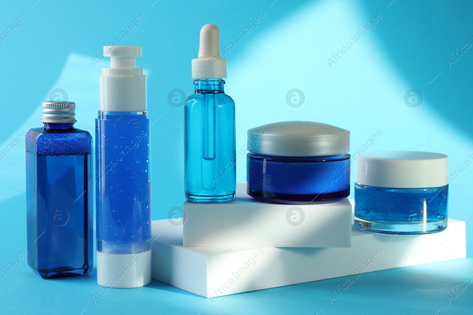 Photo of Set of luxury cosmetic products on light blue background