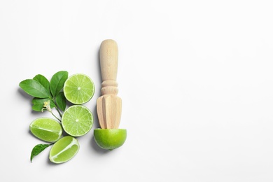 Flat lay composition with lime, mint and juicer on light background. Refreshing beverage ingredients