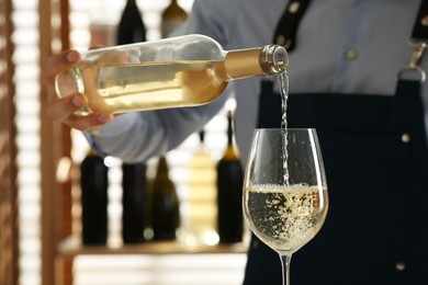 Photo of Bartender pouring wine into glass in restaurant, closeup