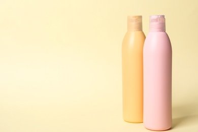 Photo of Bottles with cosmetic products on yellow background. Mockup for design