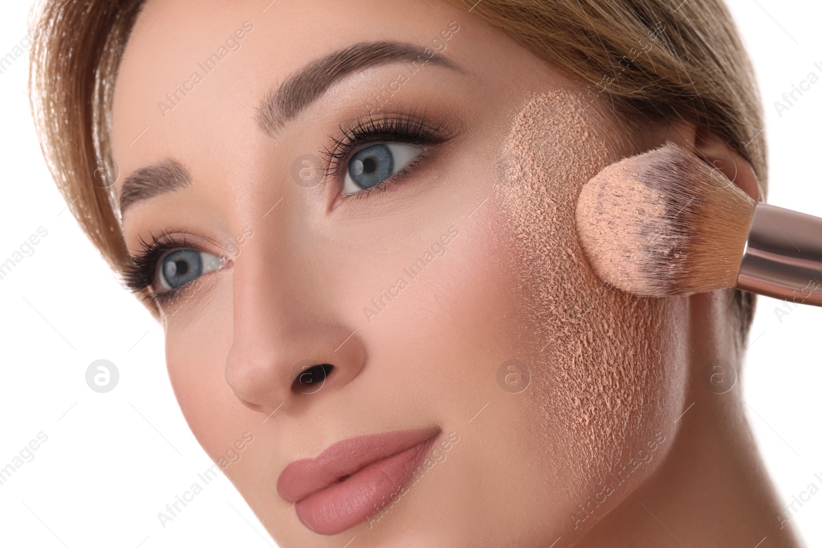 Photo of Beautiful young woman applying face powder with brush on white background, closeup