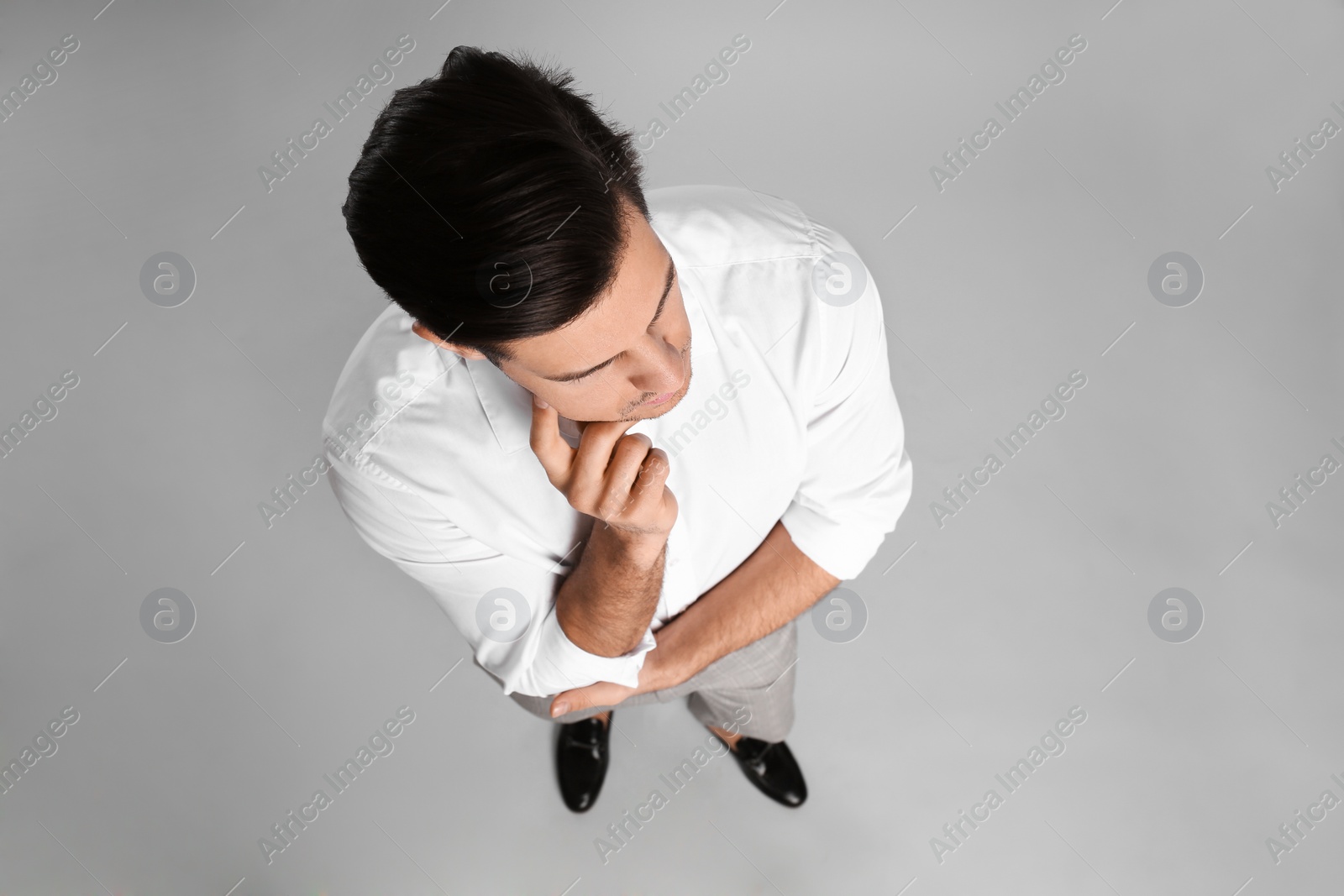 Photo of Thoughtful businessman in formal clothes on grey background, above view