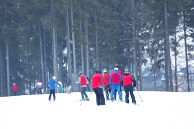 Photo of Skiers on slope at resort. Winter vacation