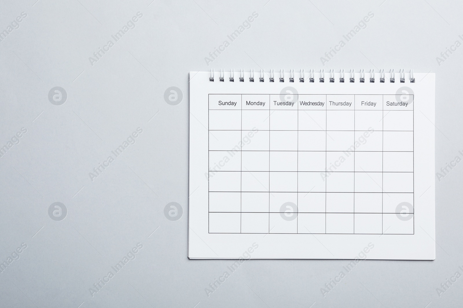 Photo of Blank calendar on light grey background, top view. Space for text