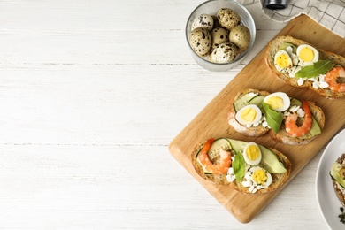 Photo of Flat lay composition with delicious bruschettas on white wooden table, space for text
