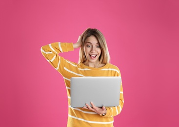 Photo of Portrait of surprised young woman in casual outfit with laptop on color background