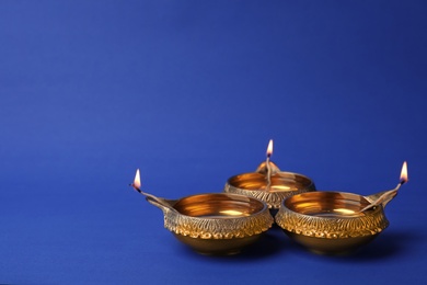 Diwali diyas or clay lamps on color background
