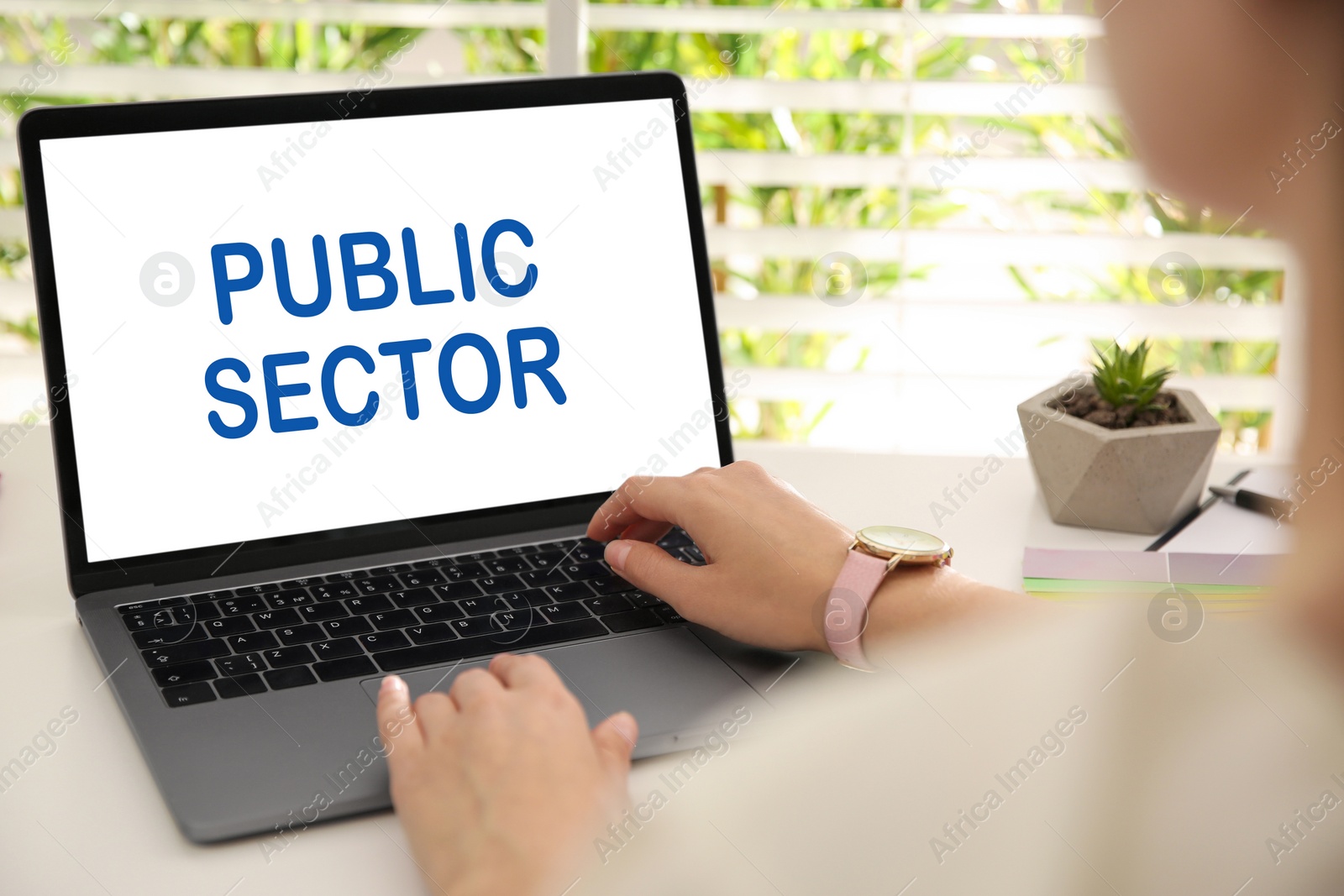 Image of Public Sector. Woman working with modern laptop at white table, closeup 