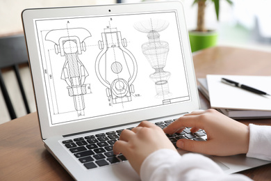 Image of Female engineer working with technical drawing on laptop indoors, closeup