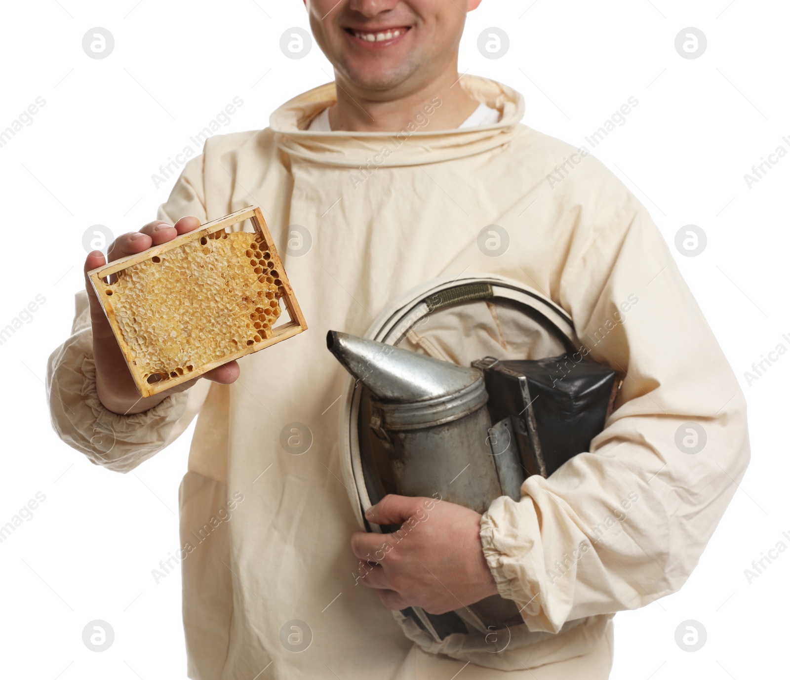 Photo of Beekeeper in uniform holding smokepot and hive frame with honeycomb on white background, closeup