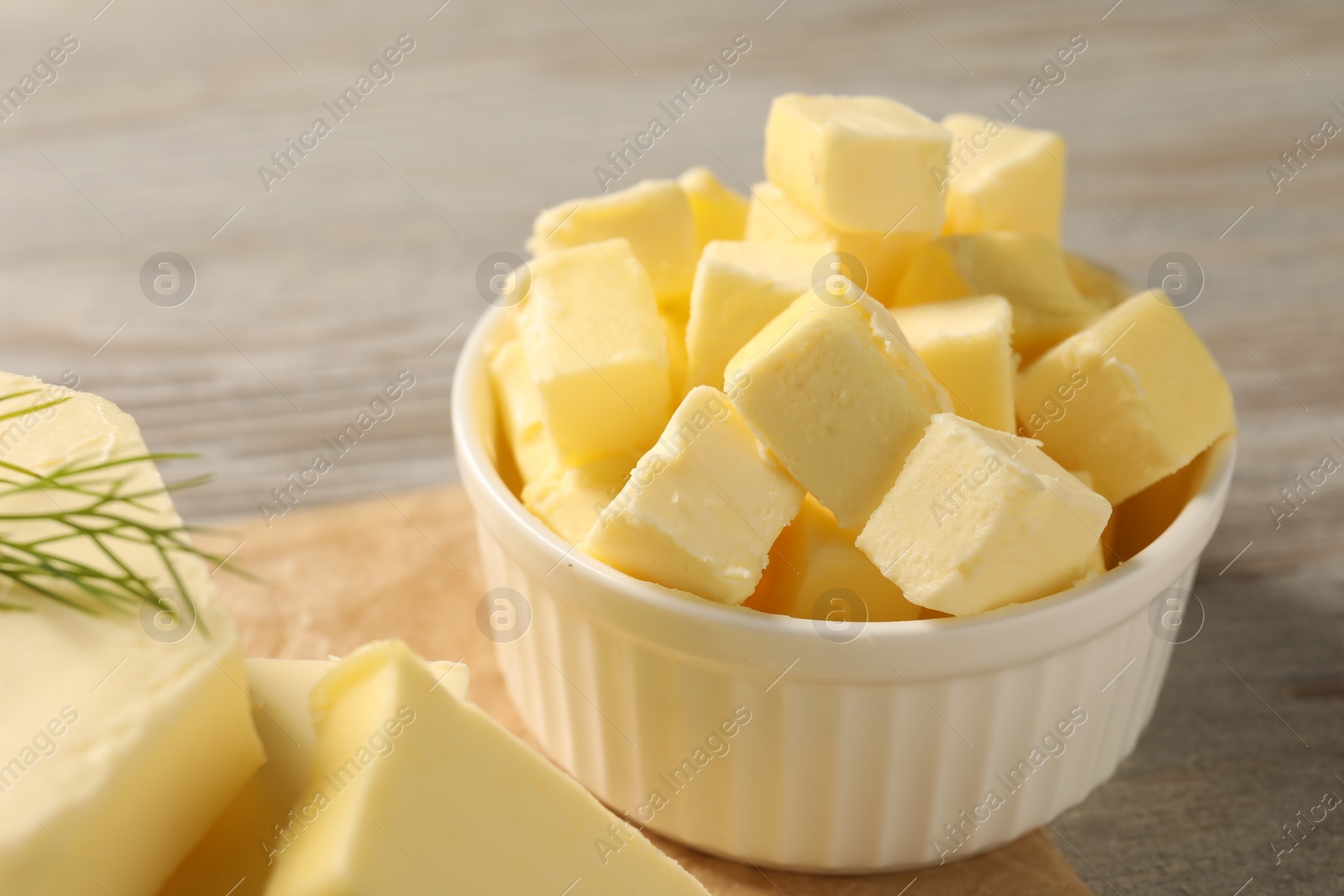 Photo of Pieces of tasty butter on wooden table, closeup