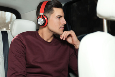 Handsome man listening to audiobook in car