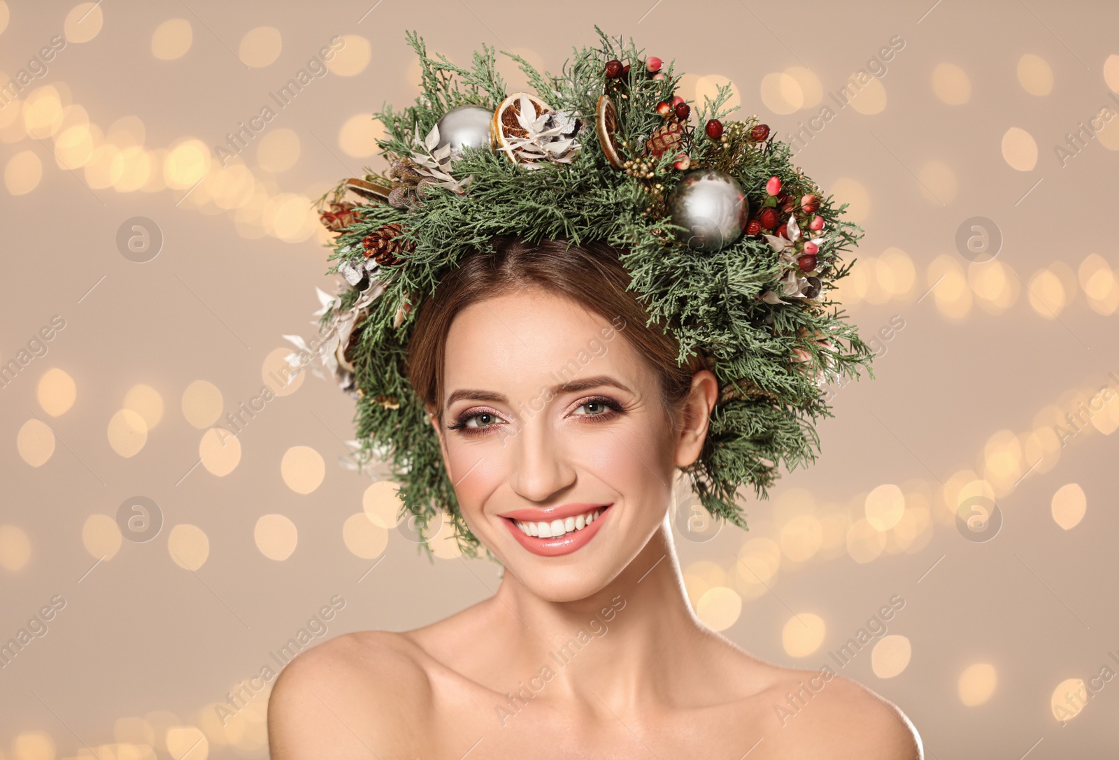 Photo of Beautiful young woman wearing Christmas wreath against blurred festive lights