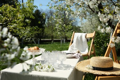 Photo of Beautiful table setting with spring flowers in garden on sunny day