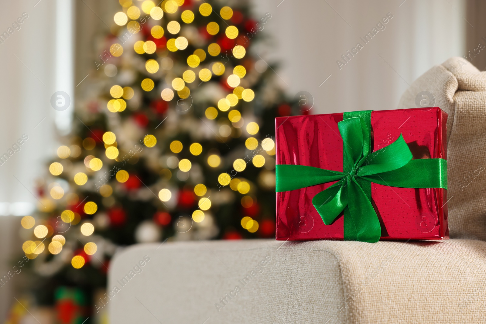 Photo of Beautiful gift box in room decorated for Christmas. Bokeh effect