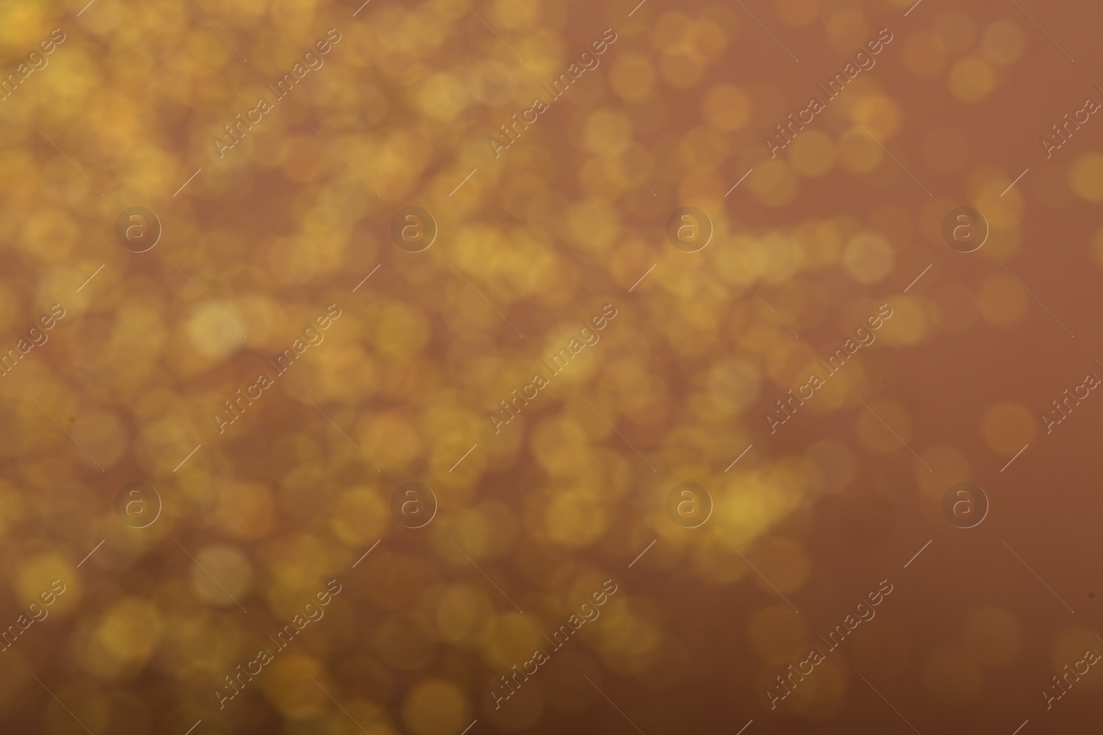 Photo of Blurred view of golden glitter on dusty rose background. Bokeh effect
