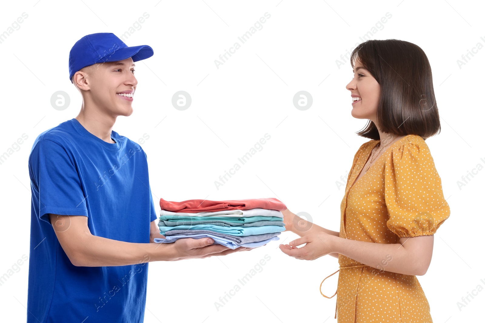 Image of Dry-cleaning delivery. Courier giving folded clothes to woman on white background