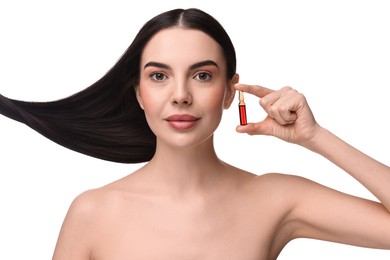 Beautiful young woman with long healthy hair holding ampoule on white background