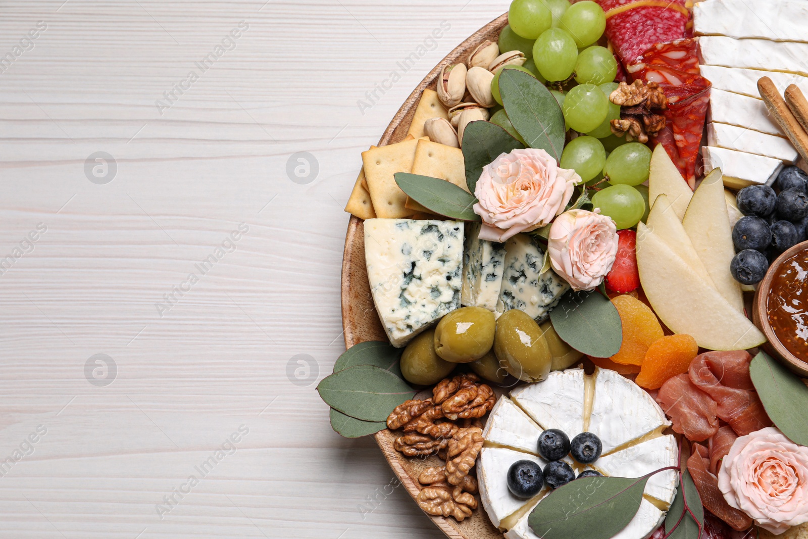 Photo of Assorted appetizer served on white wooden table, top view. Space for text