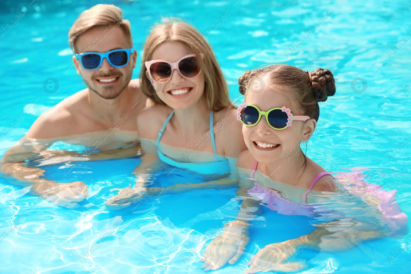 Photo of Happy family in pool on sunny day