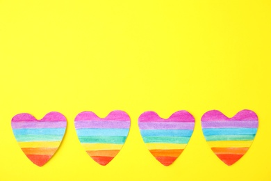 Top view of rainbow hearts on color background, space for text. Gay symbol