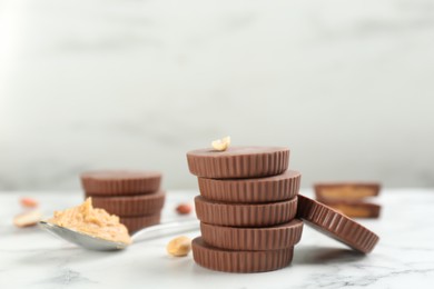 Delicious peanut butter cups on white marble table, space for text