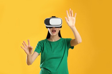 Woman using virtual reality headset on yellow background