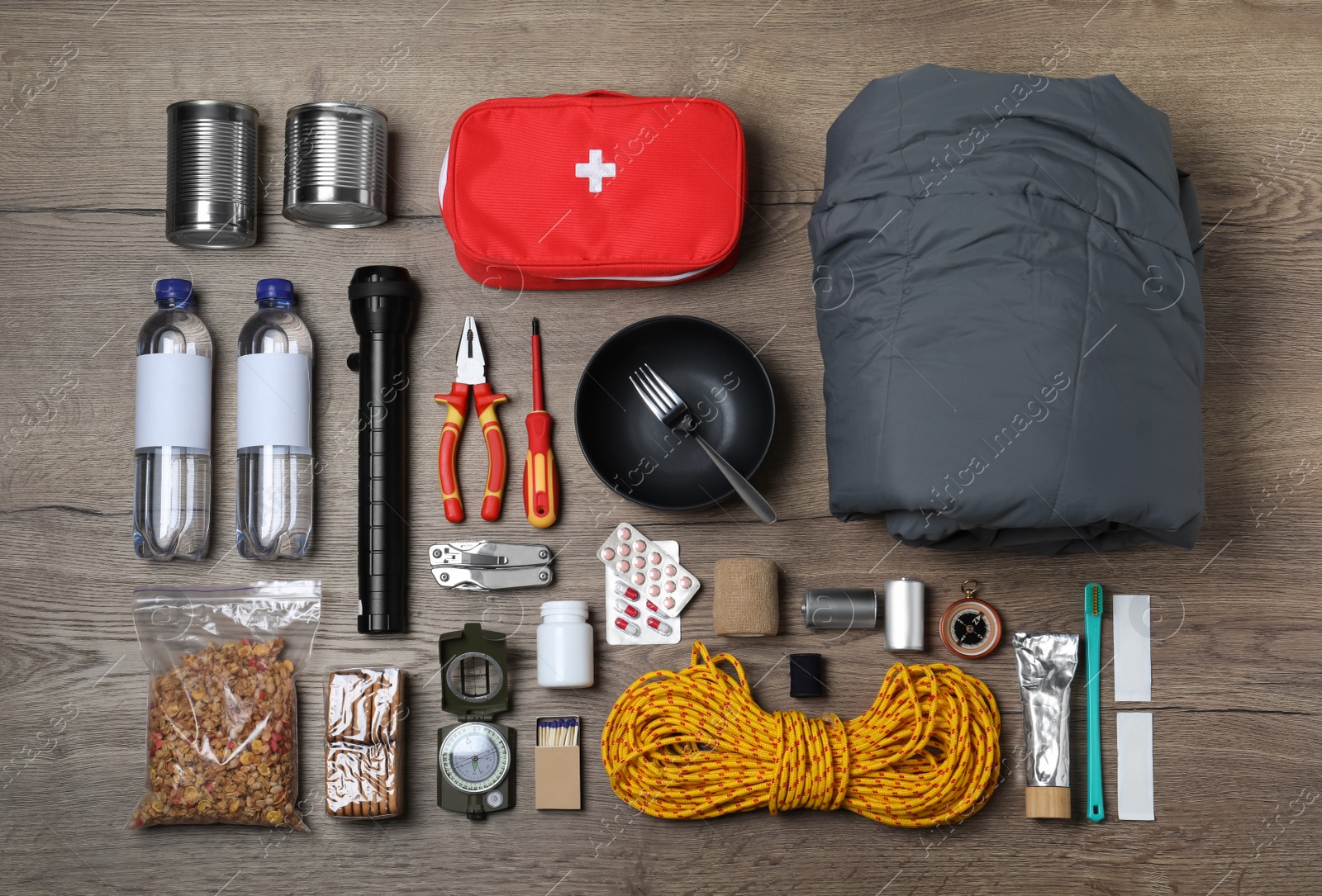 Photo of Disaster supply kit for earthquake on wooden table, flat lay