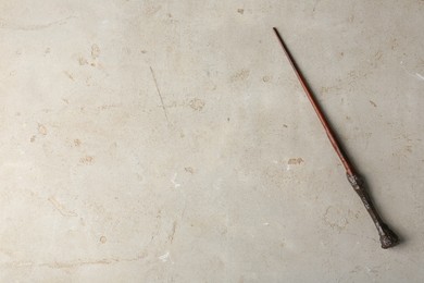Photo of One magic wand on light textured background, top view. Space for text