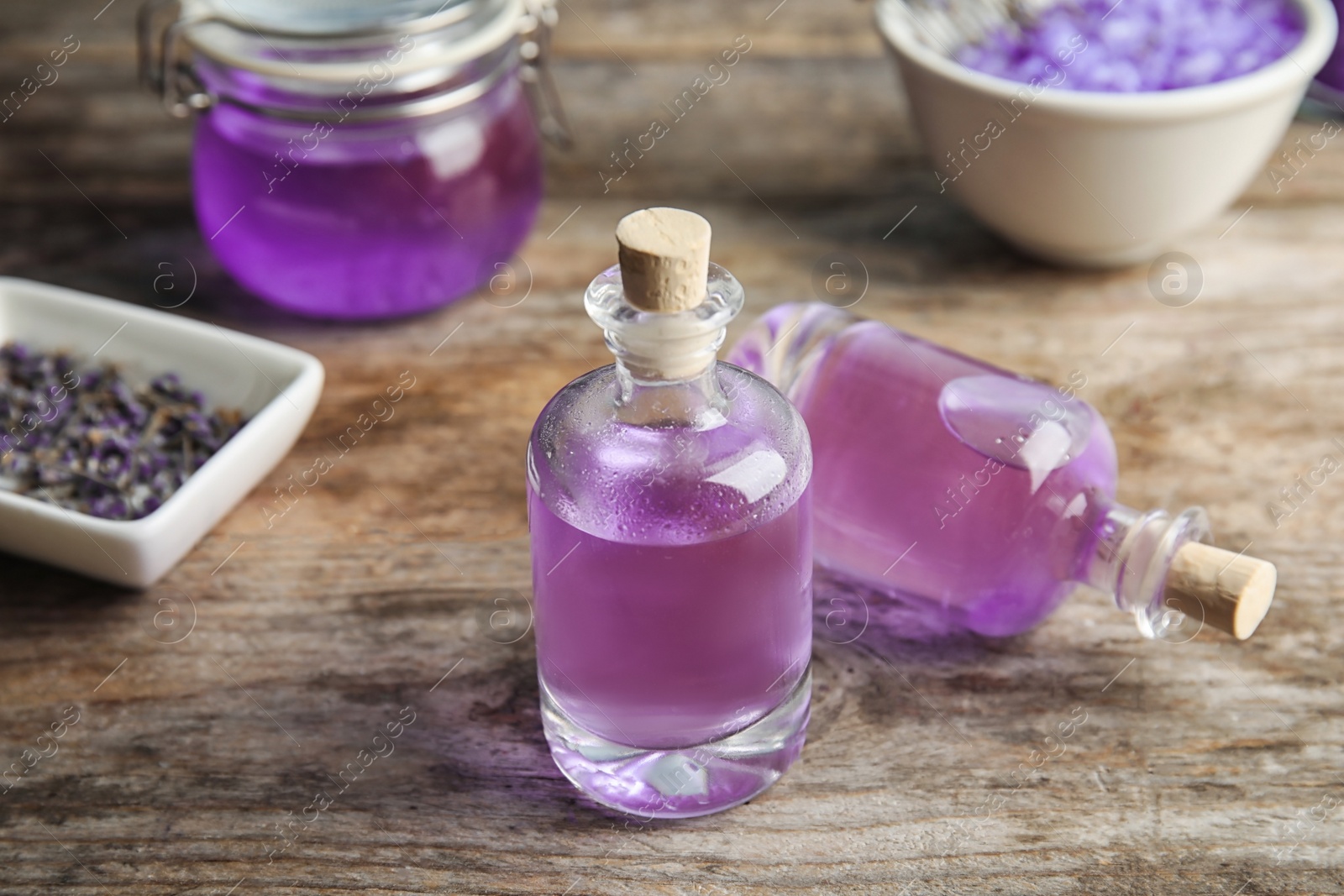 Photo of Bottles of natural lavender herbal on wooden background